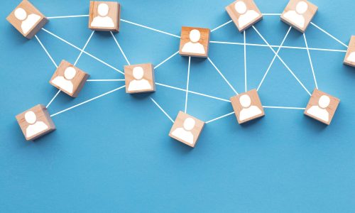 Wooden blocks connected together on a blue background. Teamwork concept